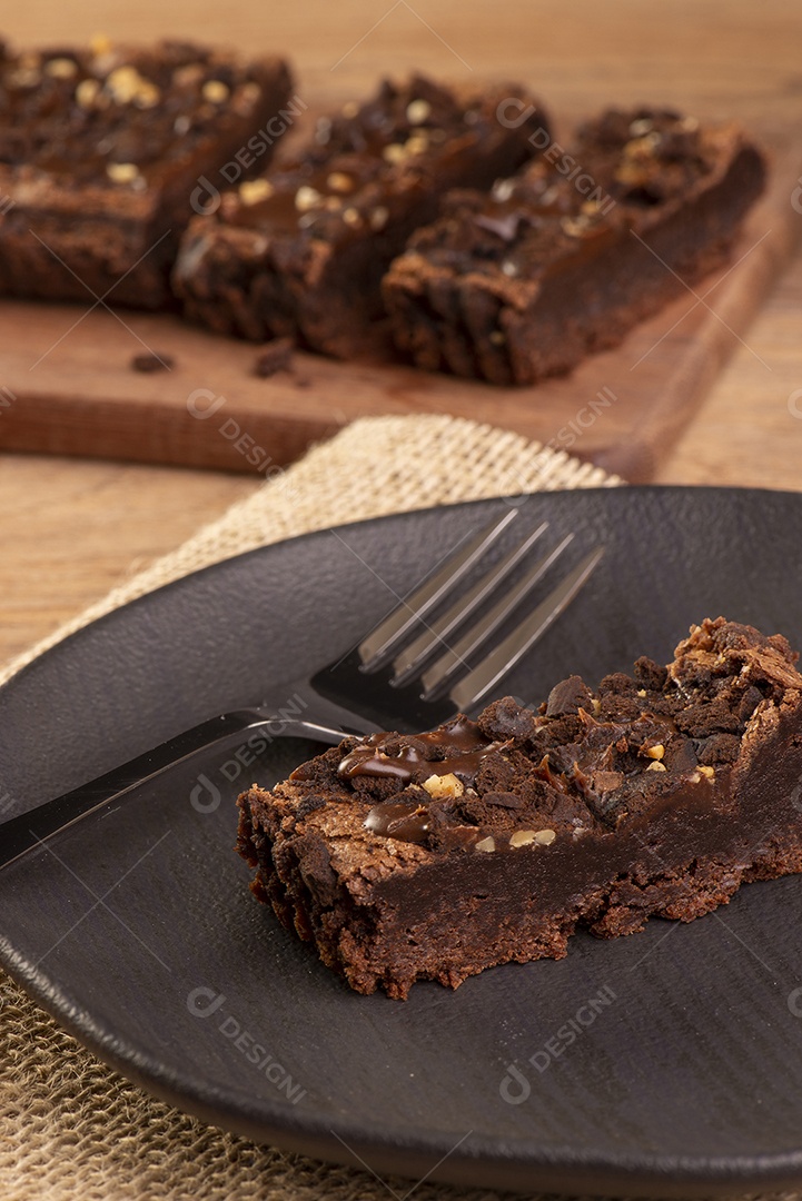 Prato com uma fatia de brownie e algumas fatias ao fundo