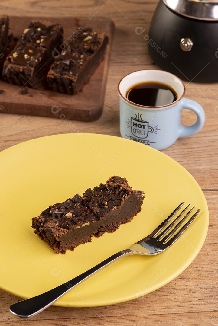 Prato com uma fatia de brownie, uma cafeteira e uma xícara de café