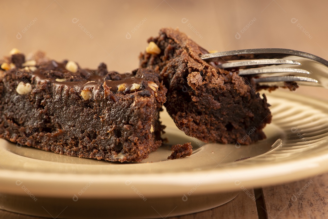 Uma fatia de brownie em um prato na mesa de madeira