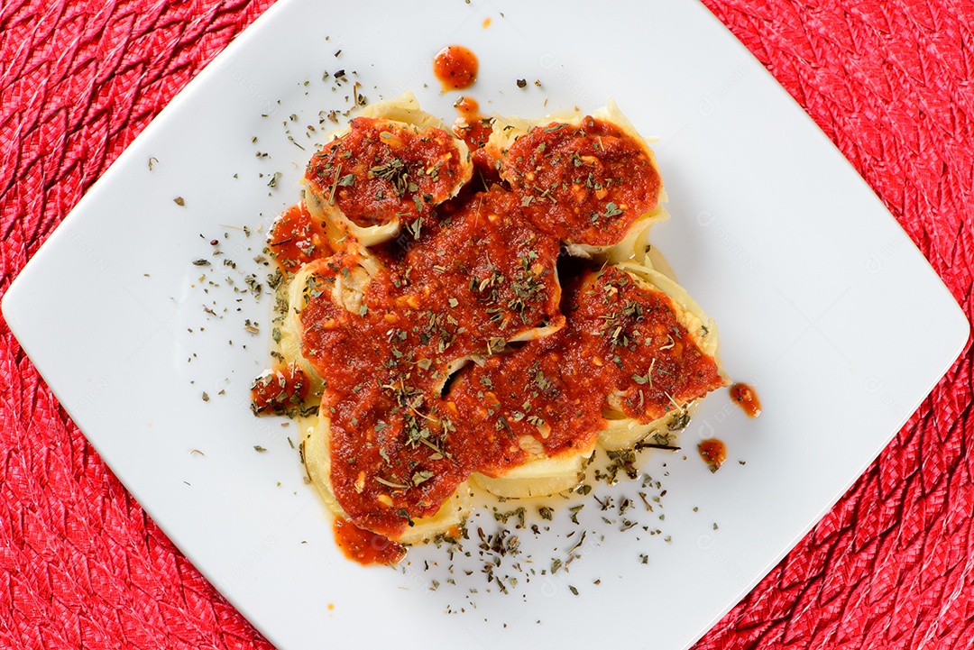 Rondelli coberto com molho vermelho e polvilhado com especiarias