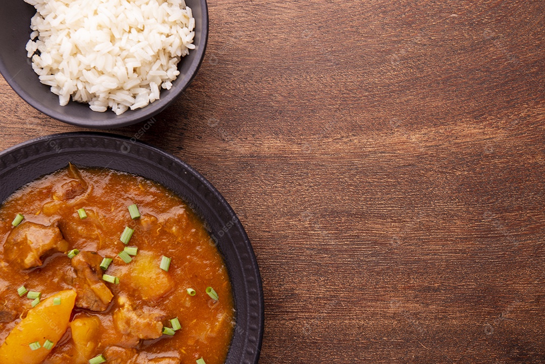 Prato com mandioca cozida e carne na mesa de madeira