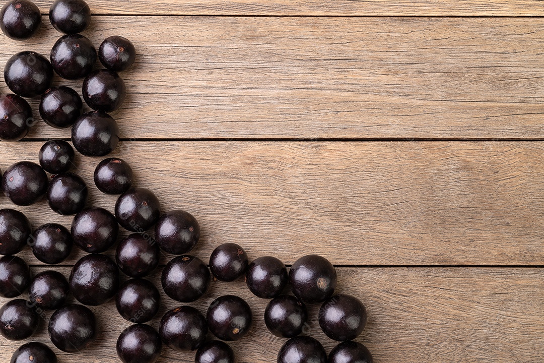 Jabuticabas sobre mesa de madeira com espaço para texto