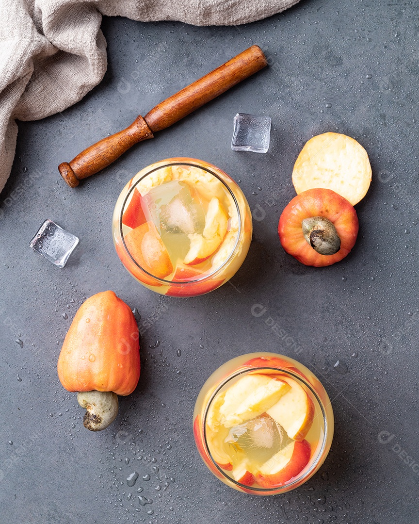 Caipirinha brasileira de caju em copos com gelo e fatias de frutas