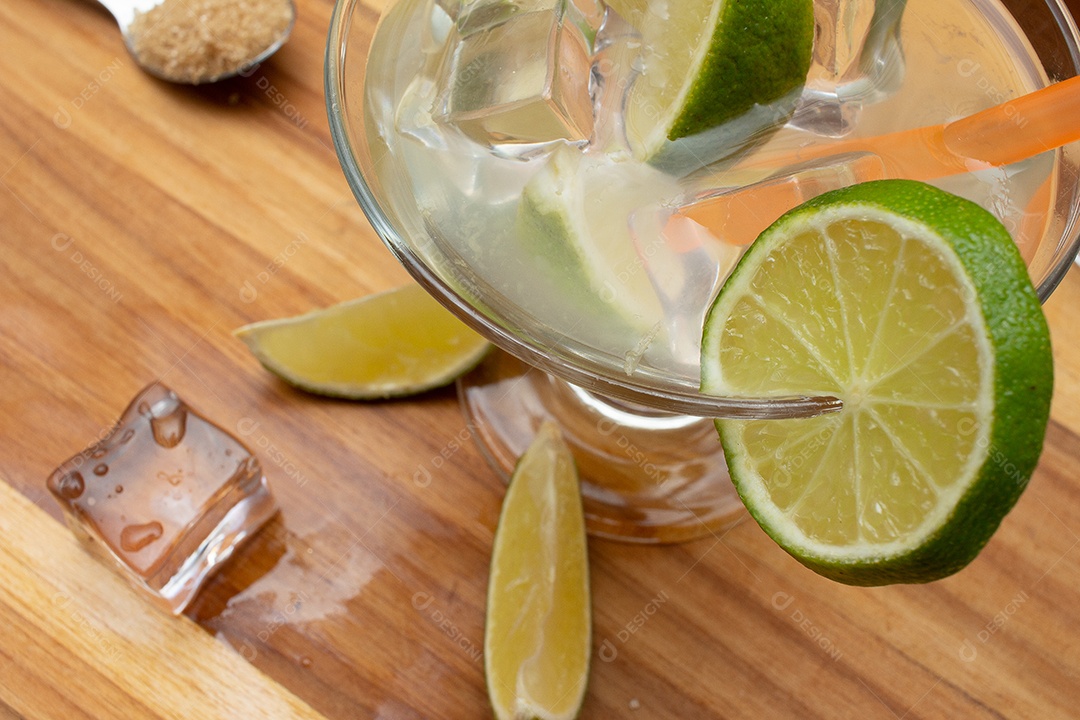 Bebida brasileira caipirinha com limão e ingredientes ao redor