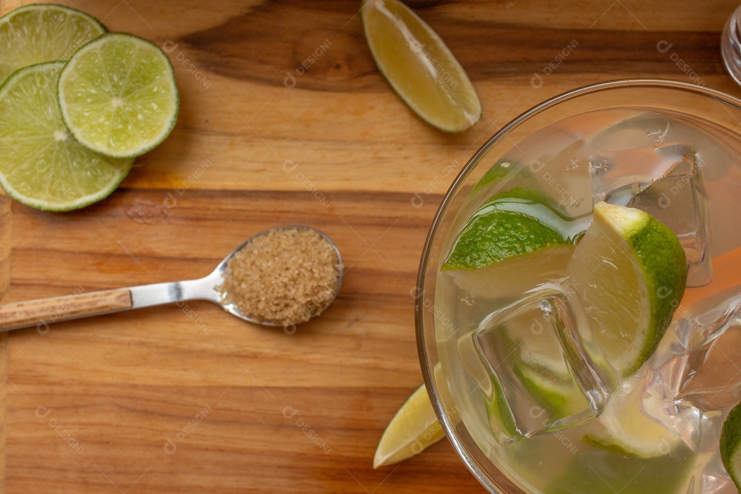 Bebida brasileira caipirinha com limão e ingredientes ao redor