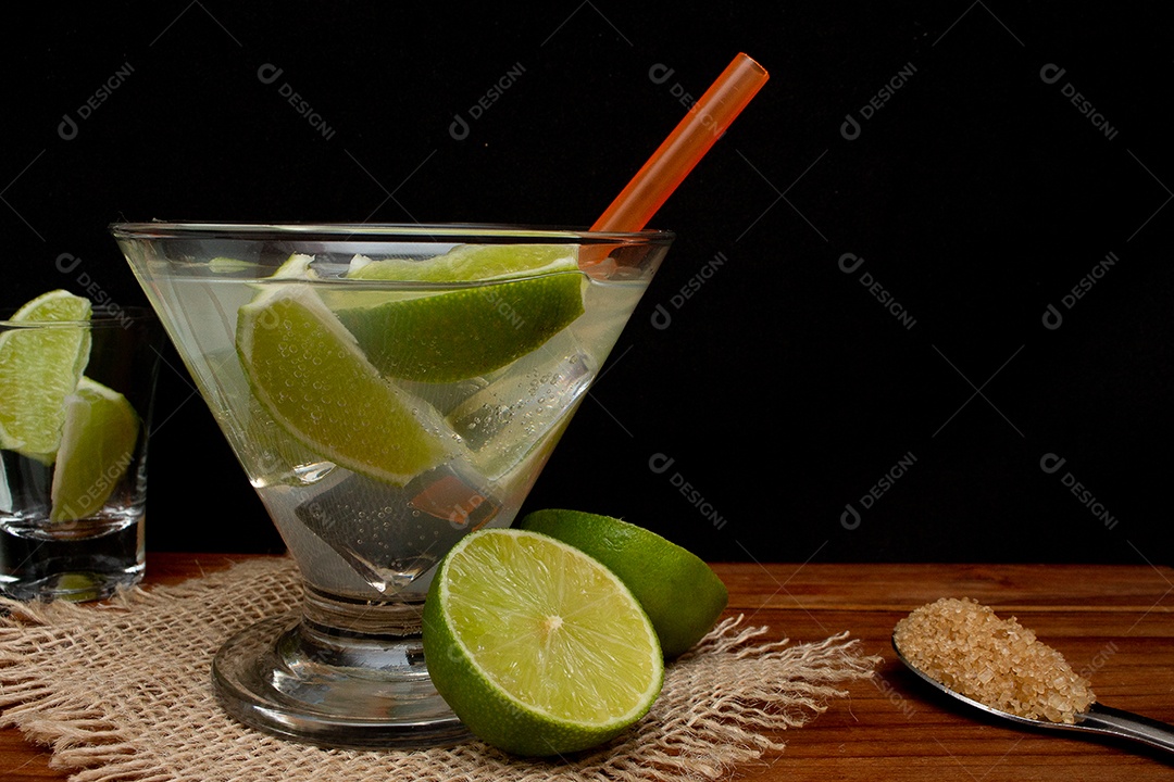 Bebida brasileira caipirinha com limão e ingredientes ao redor