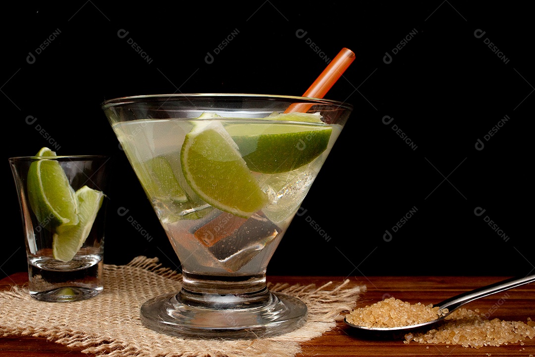 Bebida brasileira caipirinha com limão e ingredientes ao redor