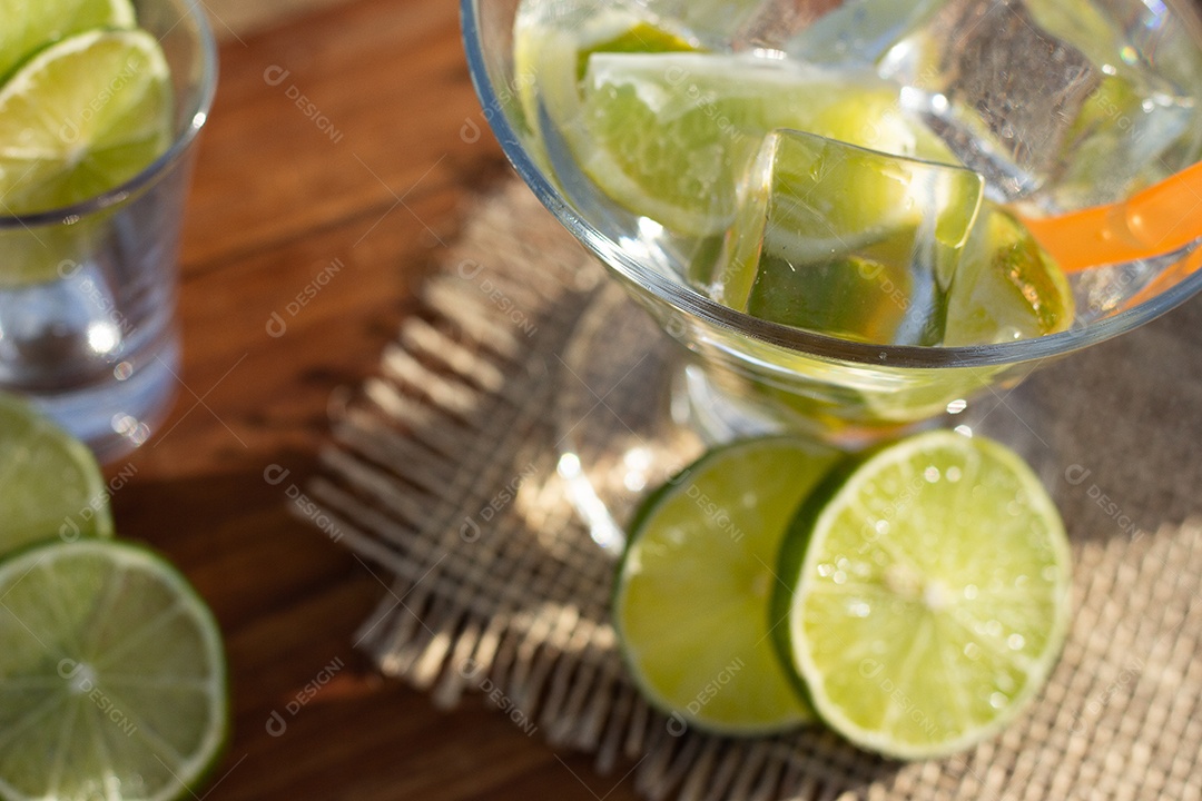 Bebida brasileira caipirinha com limão e ingredientes ao redor