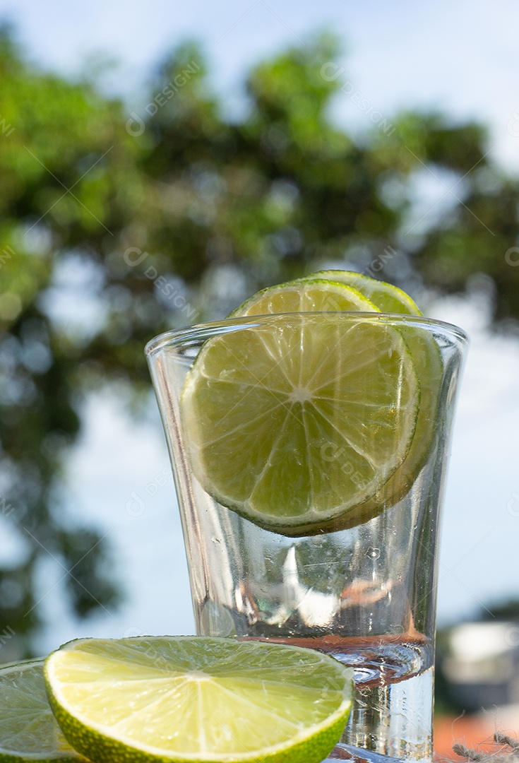 Bebida brasileira caipirinha com limão e ingredientes ao redor