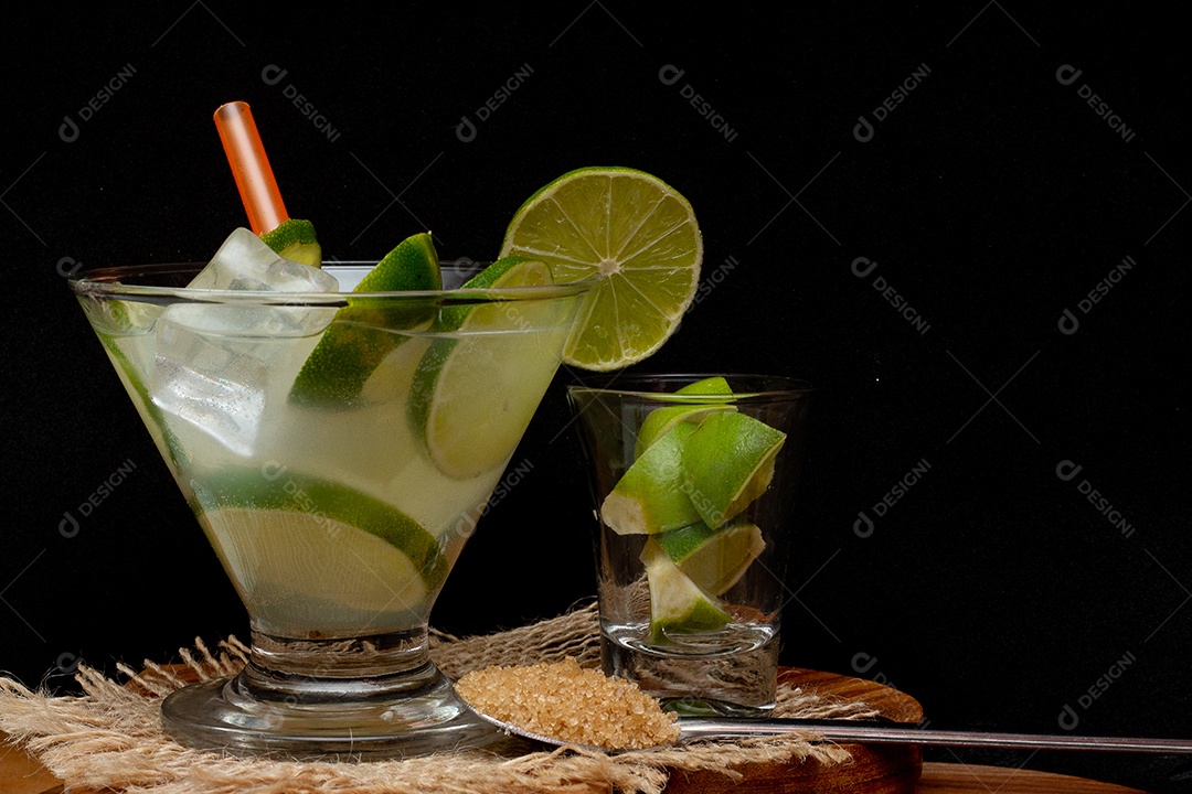 Bebida brasileira caipirinha com limão e ingredientes ao redor