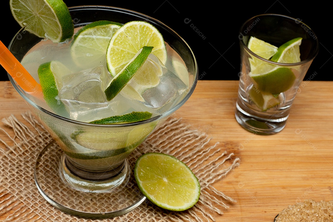 Bebida brasileira caipirinha com limão e ingredientes ao redor