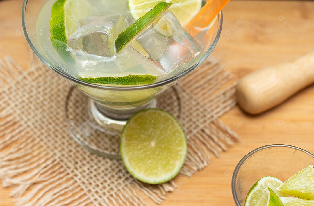 Bebida brasileira caipirinha com limão e ingredientes ao redor