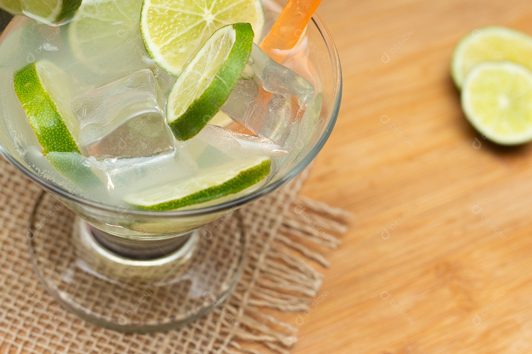 Bebida brasileira caipirinha com limão e ingredientes ao redor