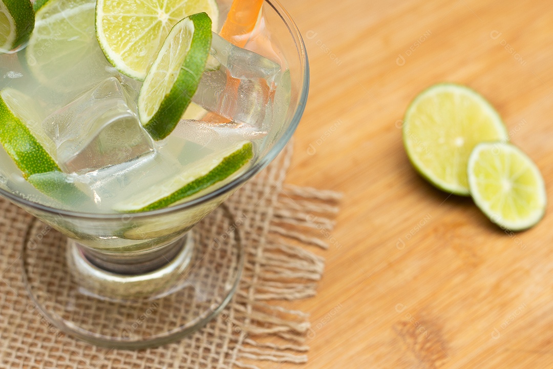 Bebida brasileira caipirinha com limão e ingredientes ao redor