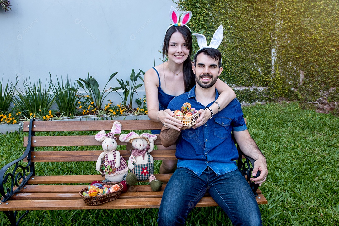 Casal de jovens orelhas de coelhinho da páscoa mostrando ovos de páscoa