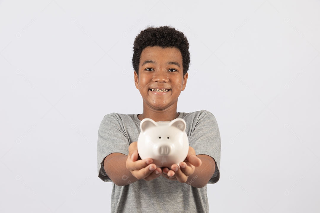 Menino jovem segurando cofrinho sobre fundo isolado