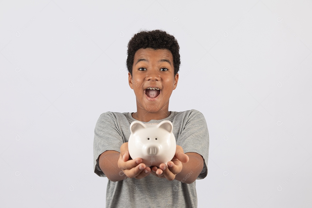 Menino jovem segurando cofrinho sobre fundo isolado