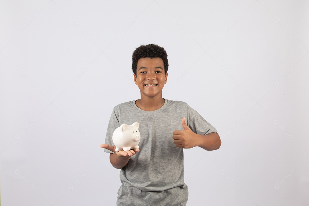 Menino jovem segurando cofrinho sobre fundo isolado