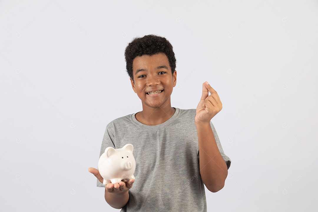 Menino jovem segurando cofrinho sobre fundo isolado