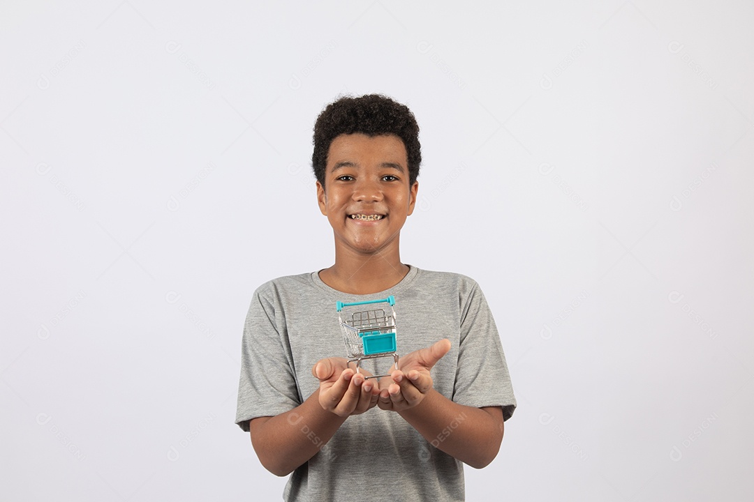 Menino jovem segurando carrinho de compras de supermercado sobre fundo isolado