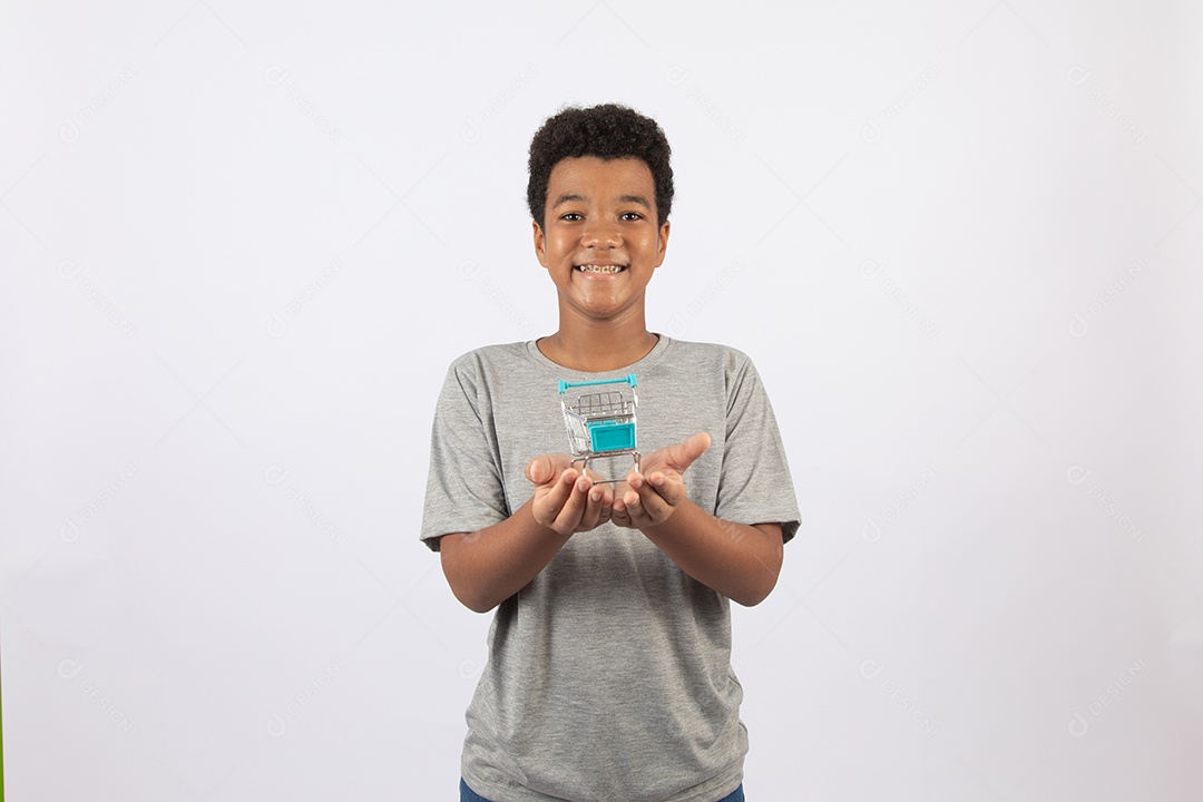 Menino jovem segurando carrinho de compras de supermercado sobre fundo isolado