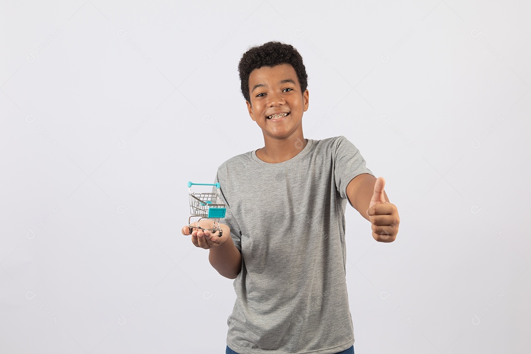 Menino jovem segurando carrinho de compras de supermercado sobre fundo isolado