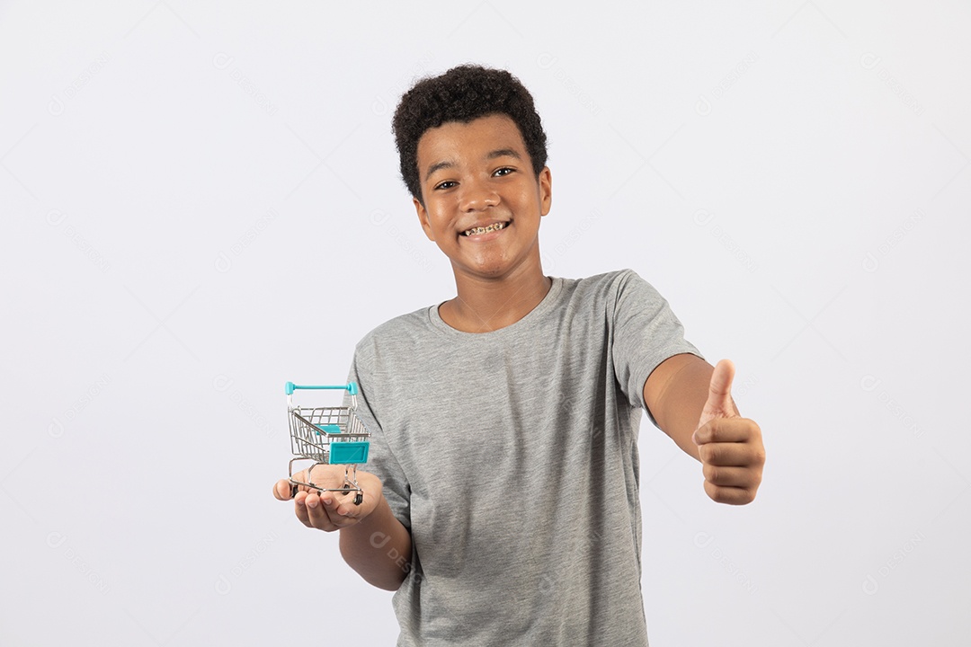 Menino jovem segurando carrinho de compras de supermercado sobre fundo isolado