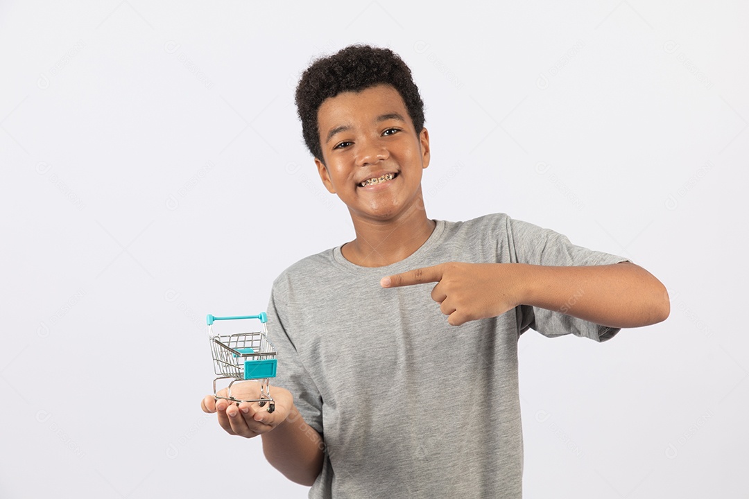 Menino jovem segurando carrinho de compras de supermercado sobre fundo isolado