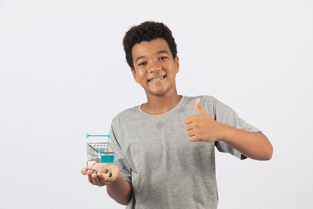 Menino jovem segurando carrinho de compras de supermercado sobre fundo isolado