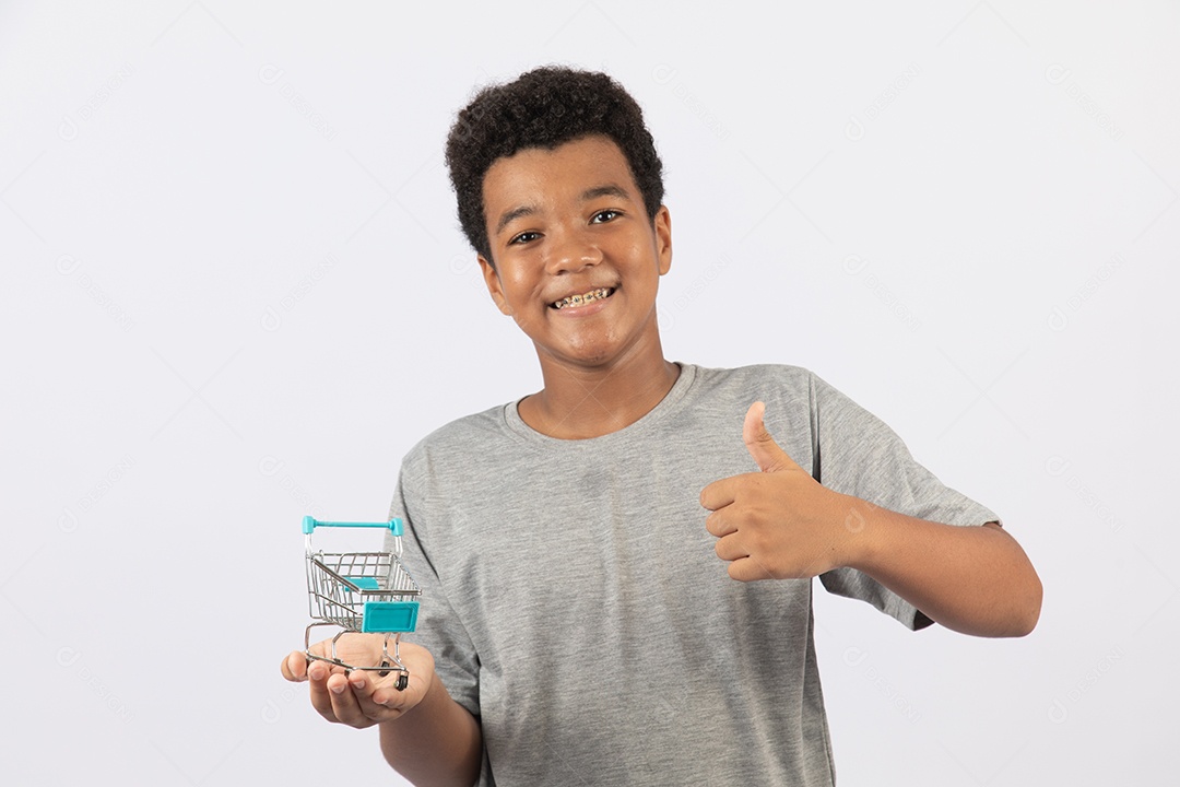 Menino jovem segurando carrinho de compras de supermercado sobre fundo isolado