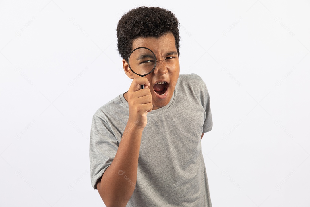 Menino jovem segurando lupa sobre fundo isolado