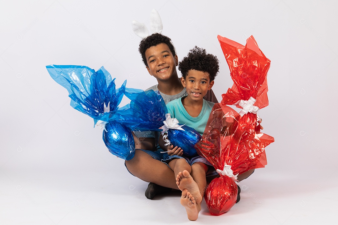 Meninos jovens irmãos segurando ovos de páscoa sobre fundo isolado