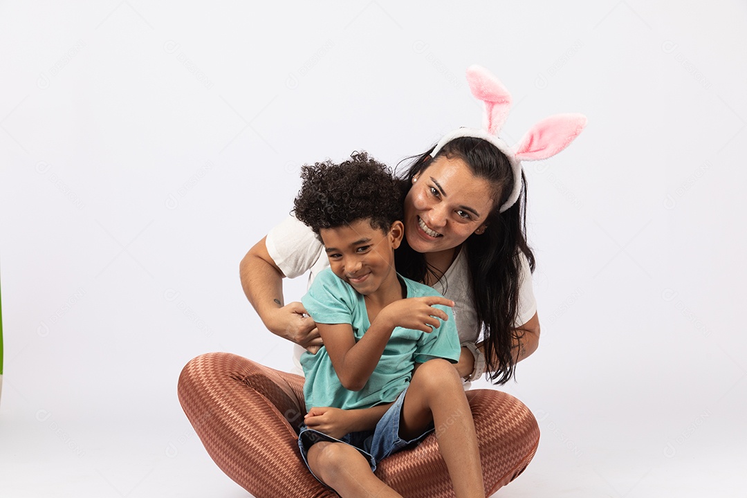 Mãe usando tiara de coelho da páscoa com seu filho brincando sobre fundo isolado