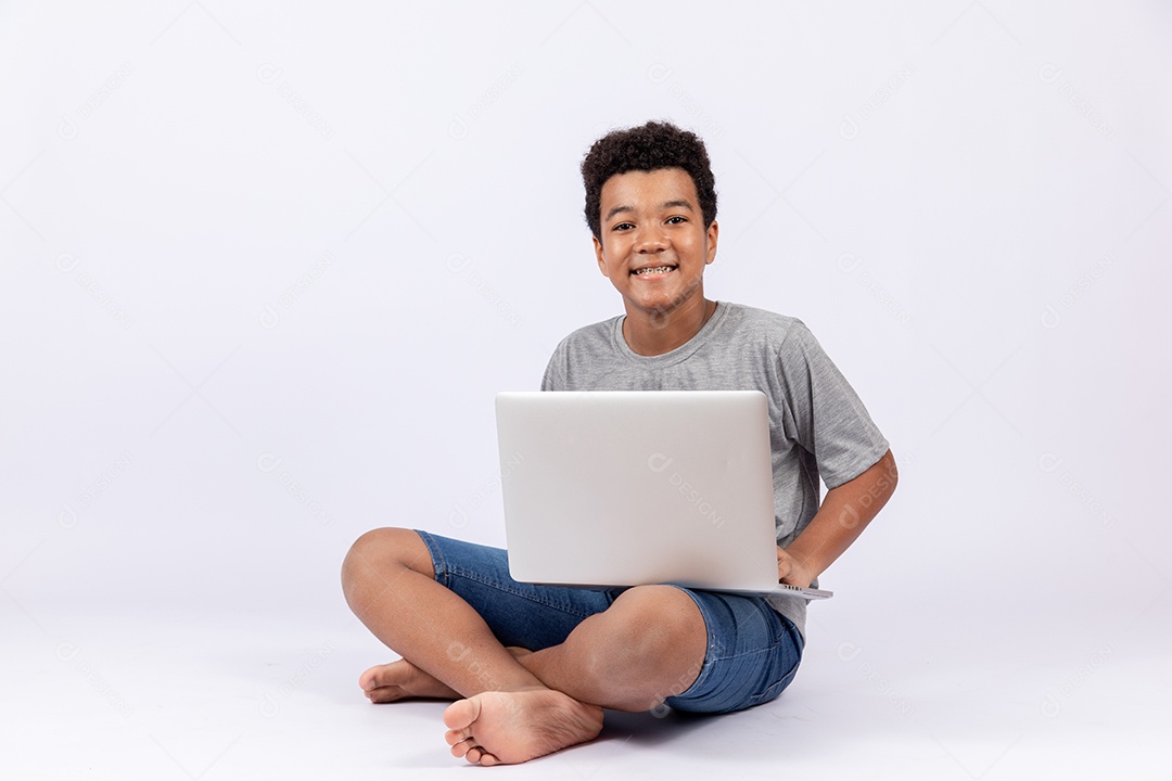 Menino jovem mexendo em seu notebook sobre fundo isolado