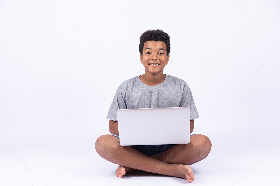 Menino jovem mexendo em seu notebook sobre fundo isolado