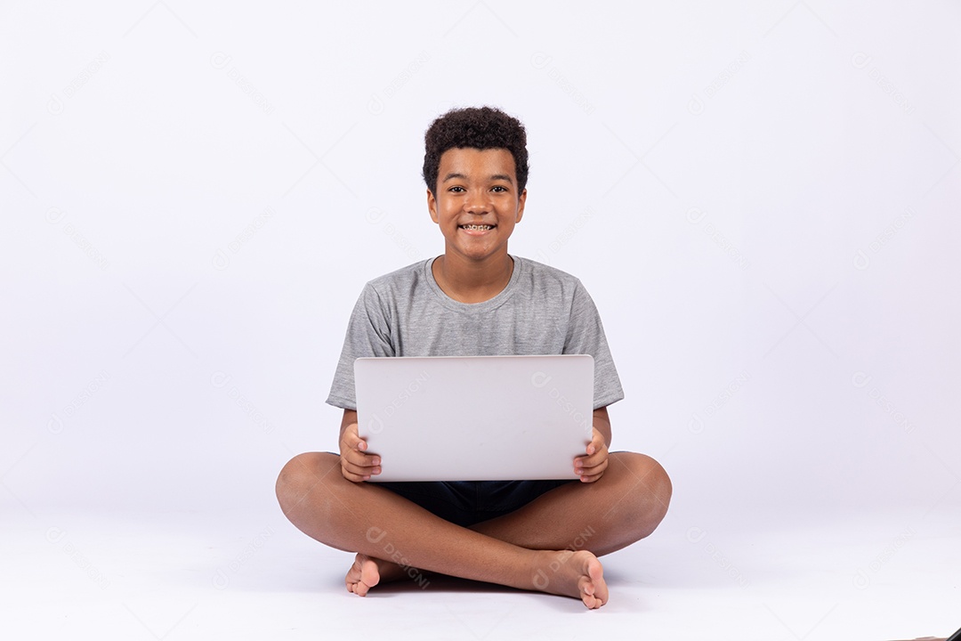 Menino jovem mexendo em seu notebook sobre fundo isolado