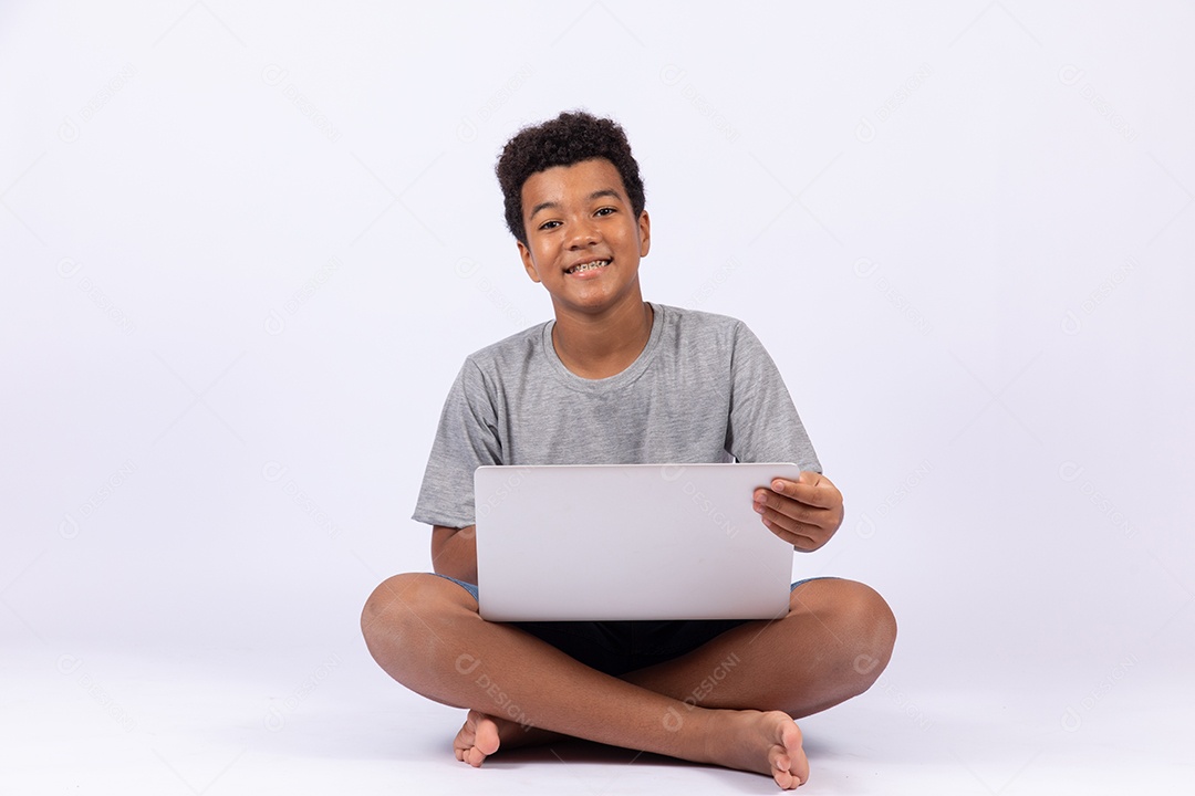 Menino jovem mexendo em seu notebook sobre fundo isolado