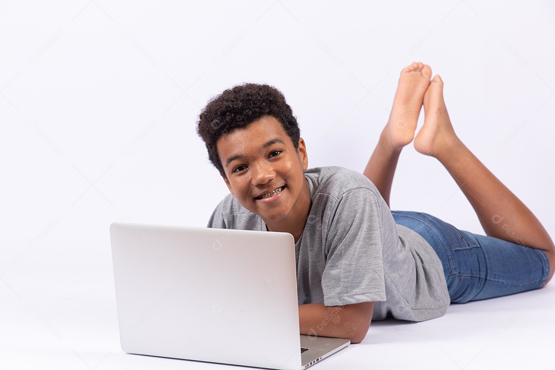 Menino jovem mexendo em seu notebook sobre fundo isolado