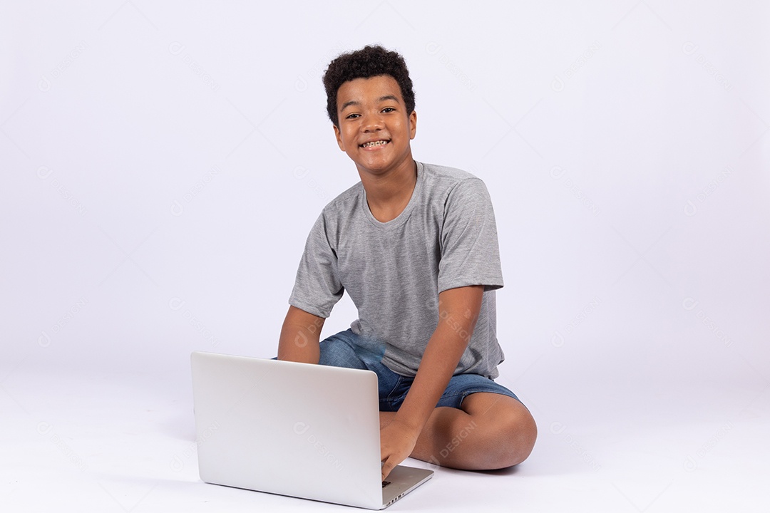 Menino jovem mexendo em seu notebook sobre fundo isolado