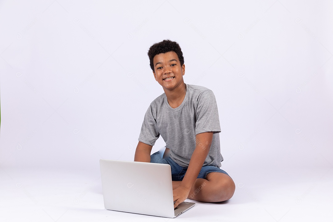 Menino jovem mexendo em seu notebook sobre fundo isolado