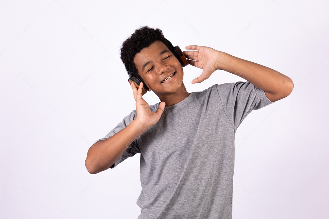 Menino jovem usando fones de ouvido ouvindo música sobre fundo isolado