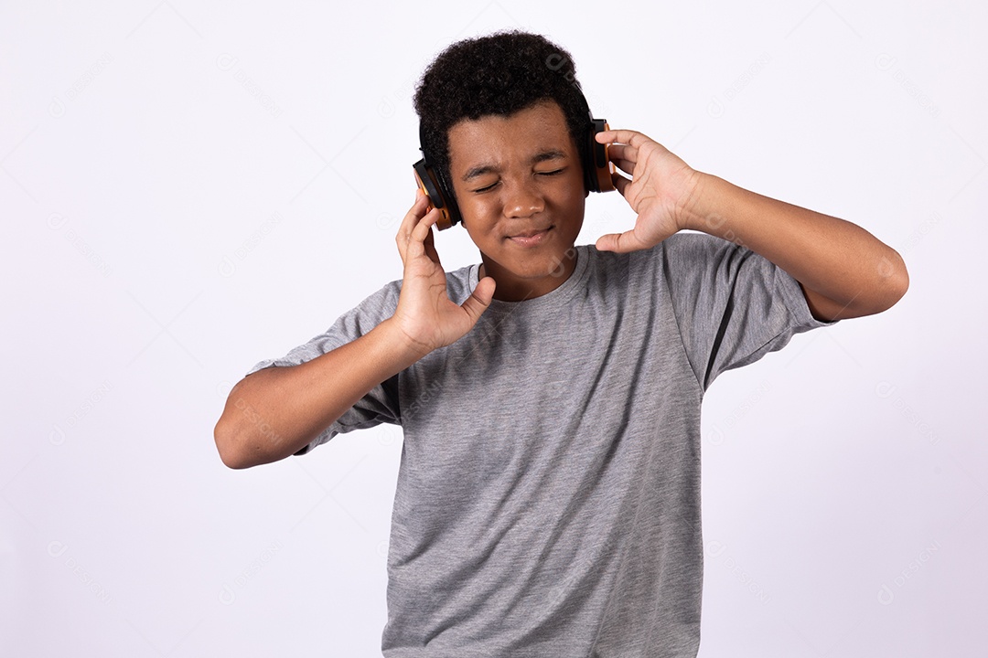 Menino jovem usando fones de ouvido ouvindo música sobre fundo isolado