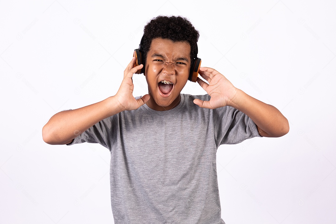 Menino jovem usando fones de ouvido ouvindo música sobre fundo isolado