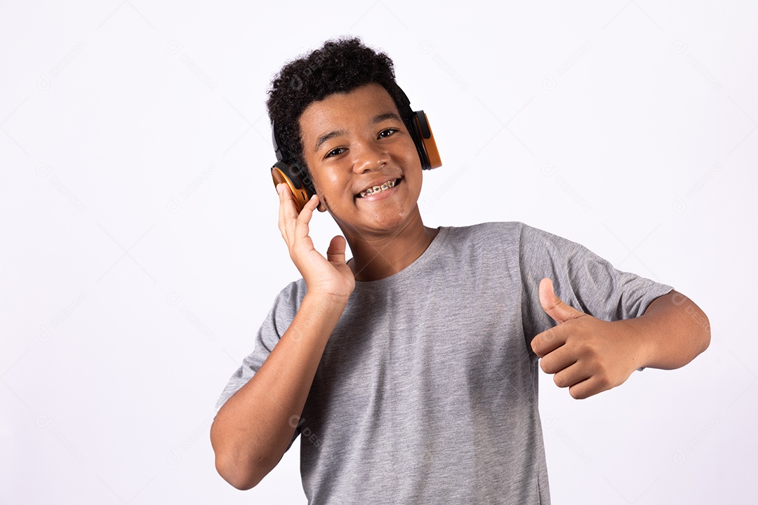 Menino jovem usando fones de ouvido ouvindo música sobre fundo isolado