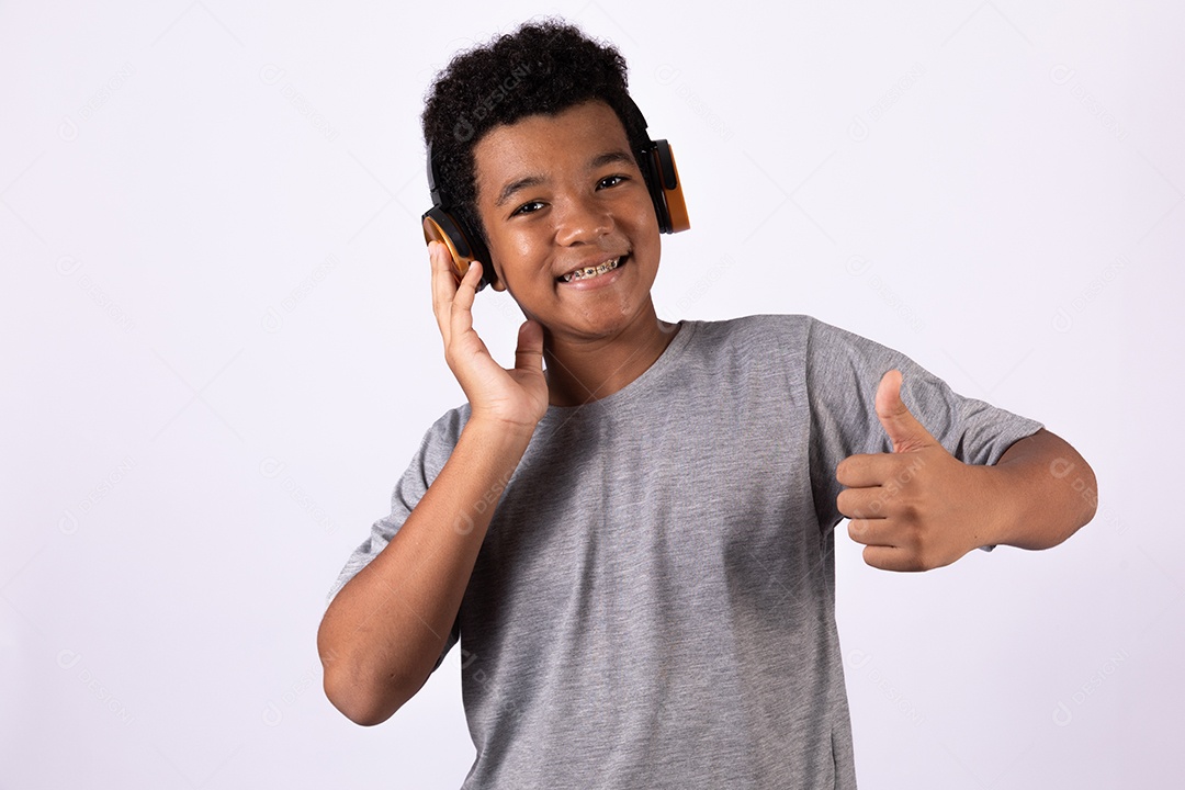 Menino jovem usando fones de ouvido ouvindo música sobre fundo isolado