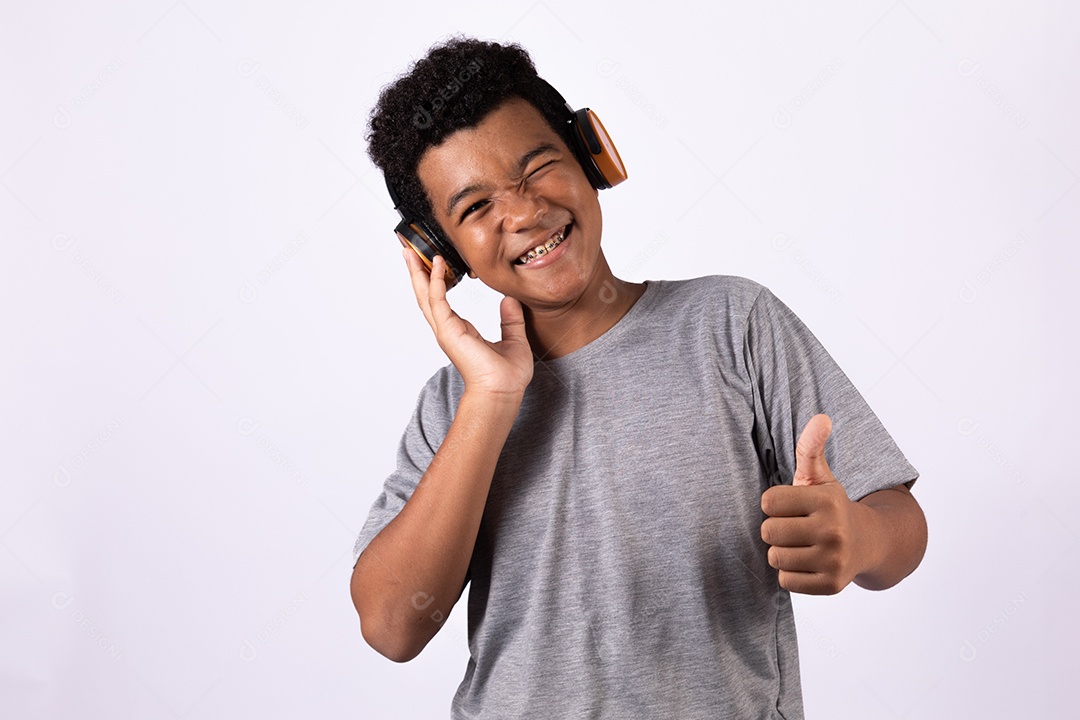 Menino jovem usando fones de ouvido ouvindo música sobre fundo isolado