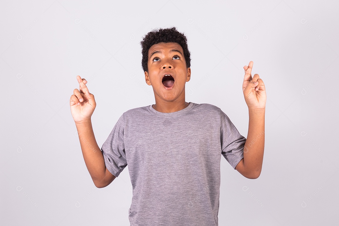 Menino jovem com dedos cruzados sobre fundo isolado