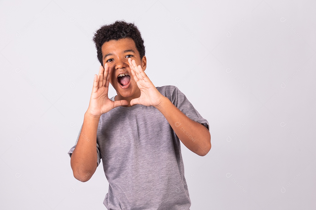 Menino jovem fazendo expressões gritando sobre fundo isolado