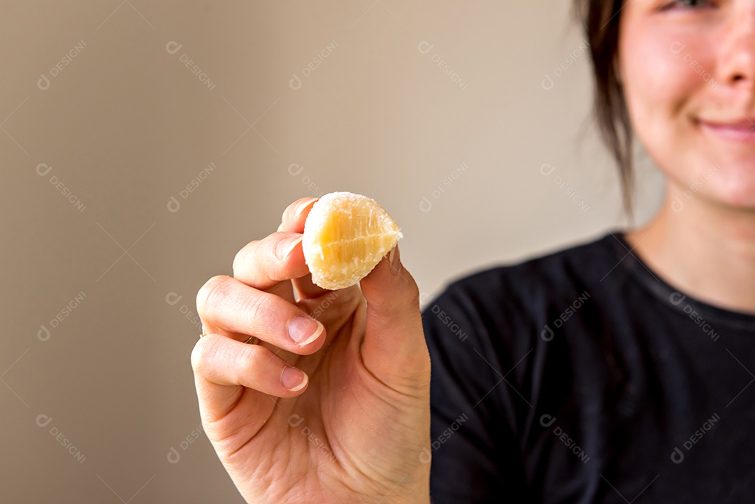 Menina segurando doce de coco e coco nas mãos