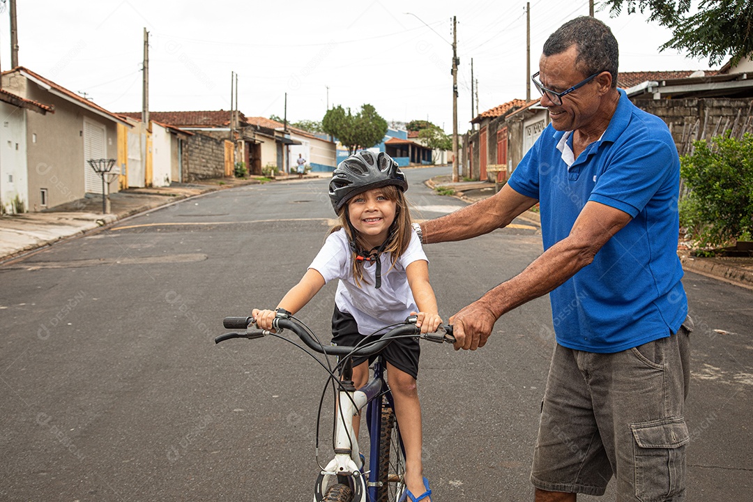 Pai ensinado sua filha a andar de bicicleta